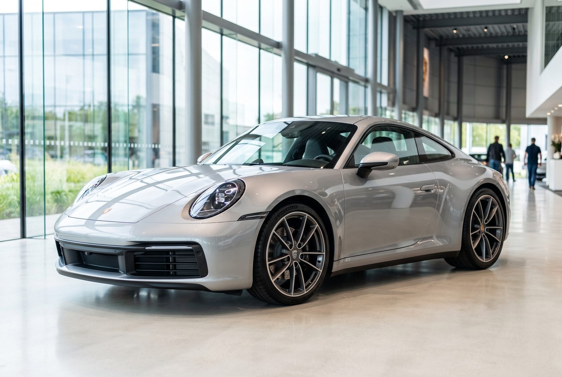 Silbergrauer Porsche 911 Carrera S von schräg vorne im Ausstellungsraum.