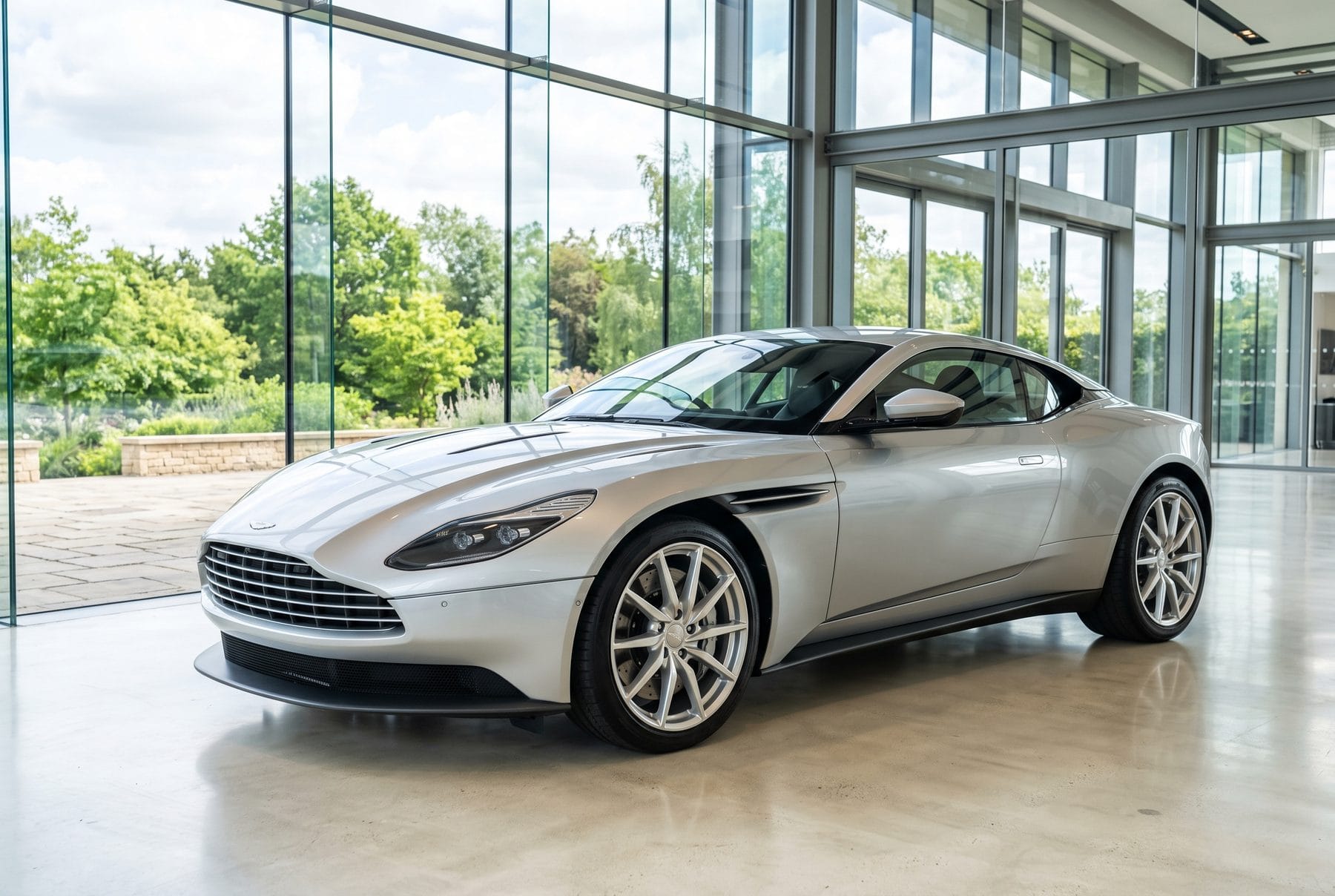 Silberner Aston Martin DB11 V8 von schräg vorne im Ausstellungsraum.