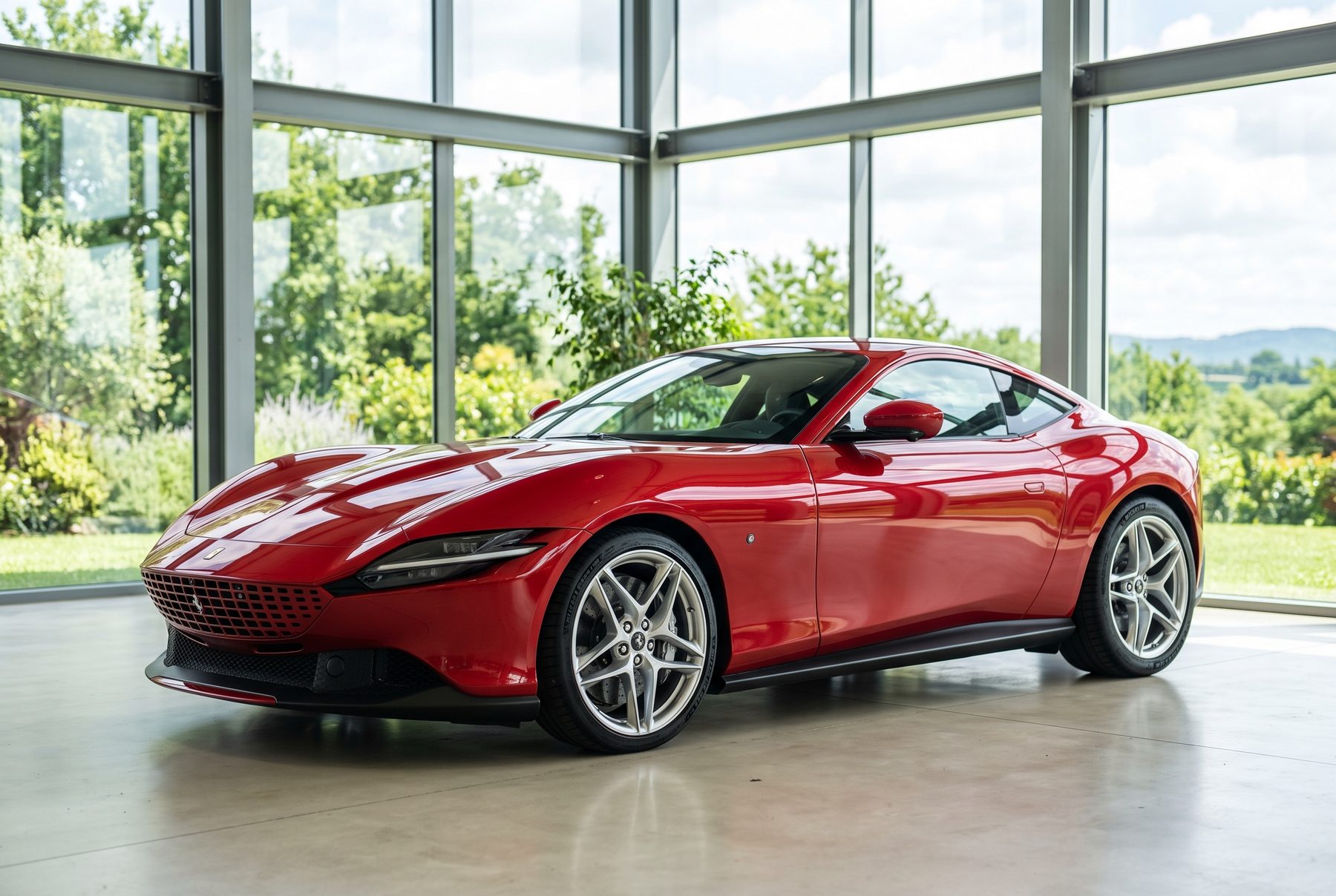 Roter Ferrari Roma von schräg vorne im Ausstellungsraum.