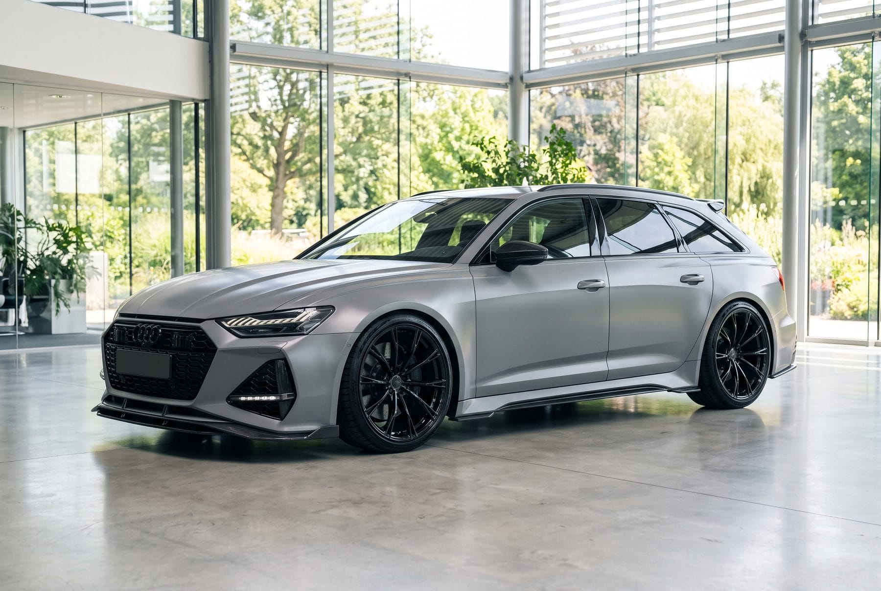 Grauer Audi RS 6 Avant von schräg vorne im Ausstellungsraum.