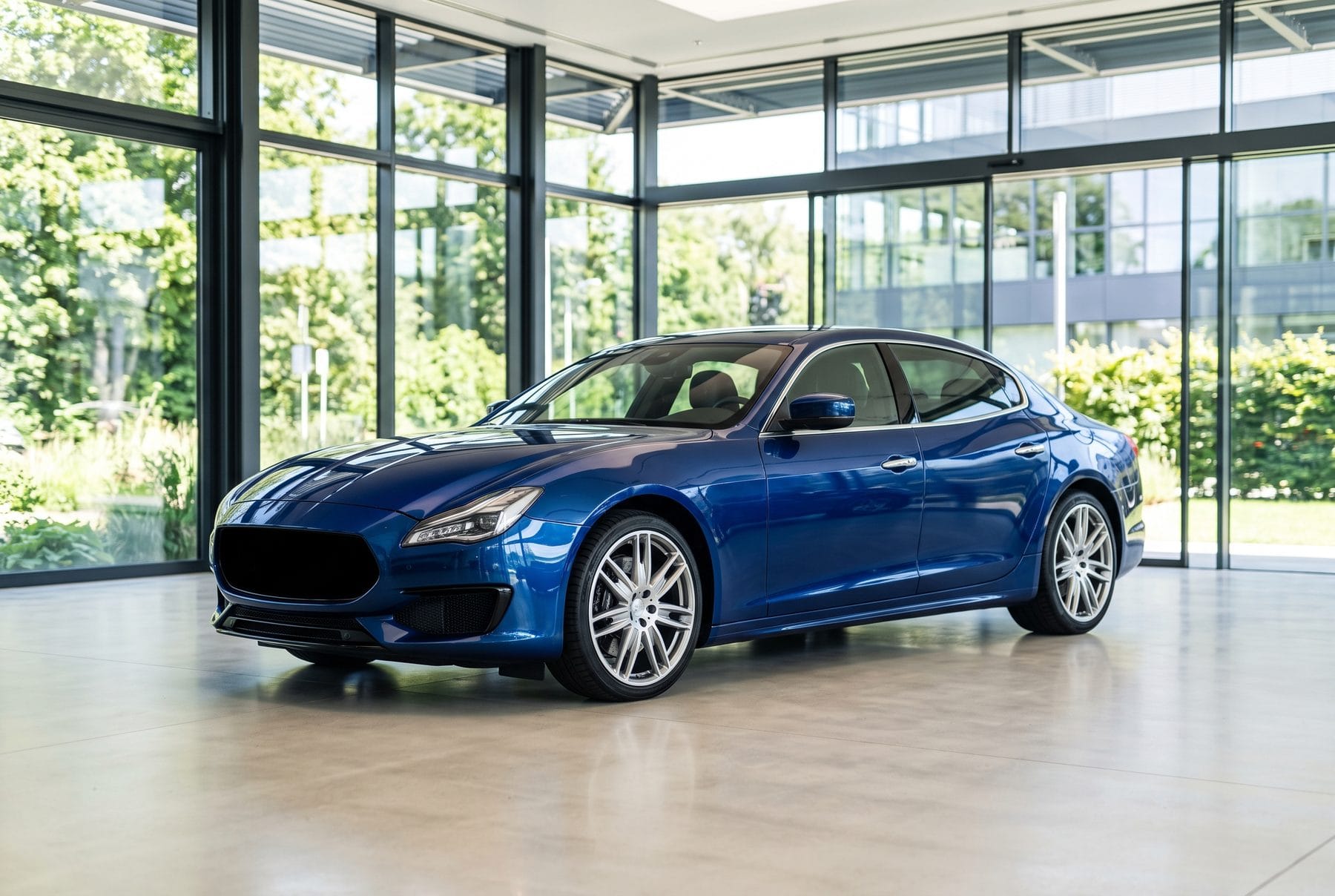 Dunkelblaue Maserati Quattroporte Limousine von schräg vorne im Ausstellungsraum.