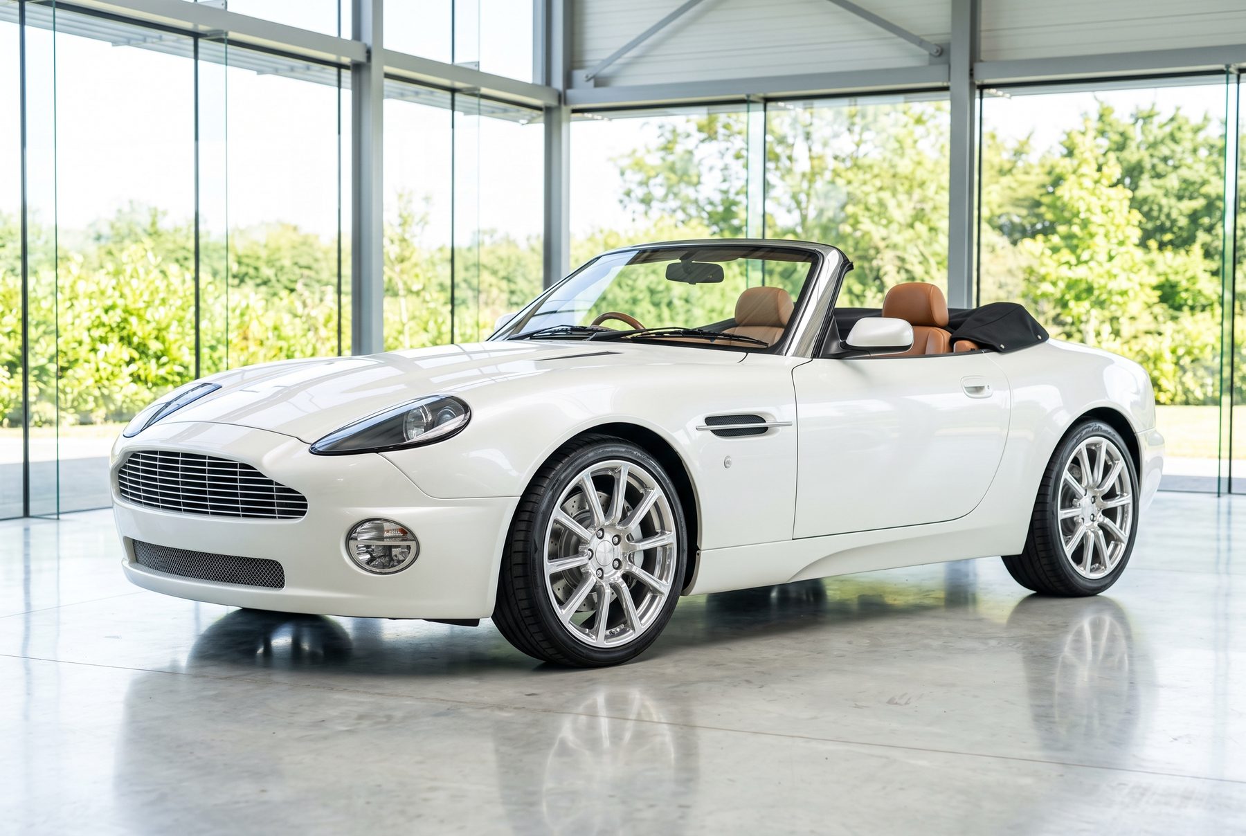Weißer offener Aston Martin Vanquish Volante von schräg vorne im Ausstellungsraum.